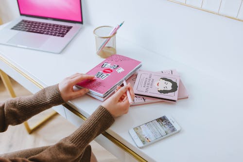 Person Holding a Notebook and Pen