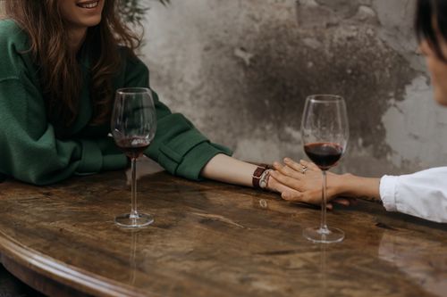 Free A romantic moment shared over red wine in an intimate indoor setting. Stock Photo