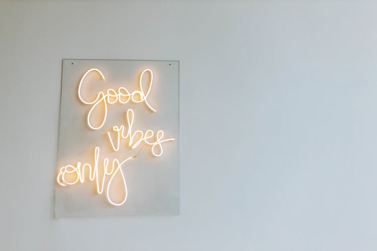 White Led Light Sign On Glass Hanging On Gray Wall