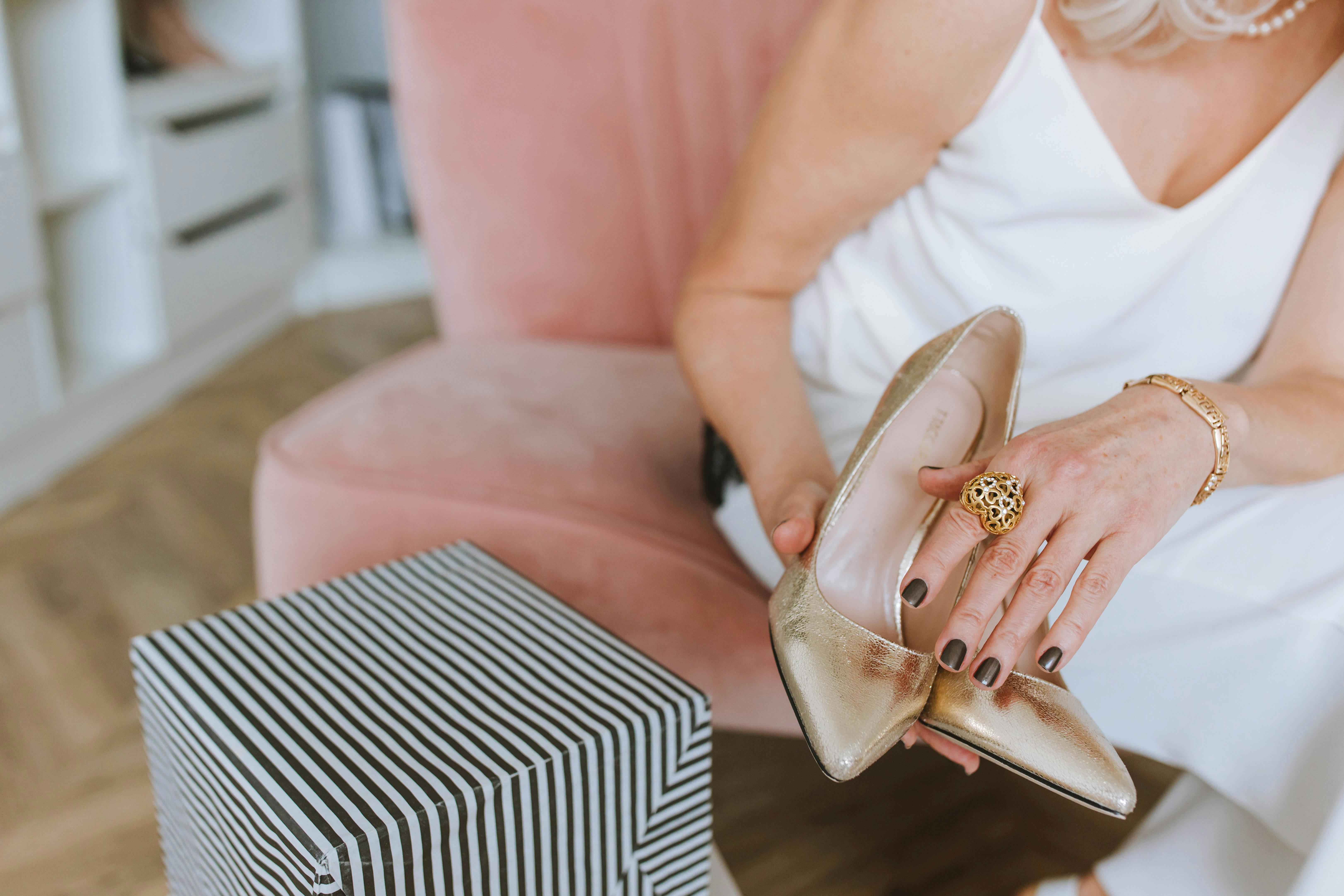 a person s hands holding shoes