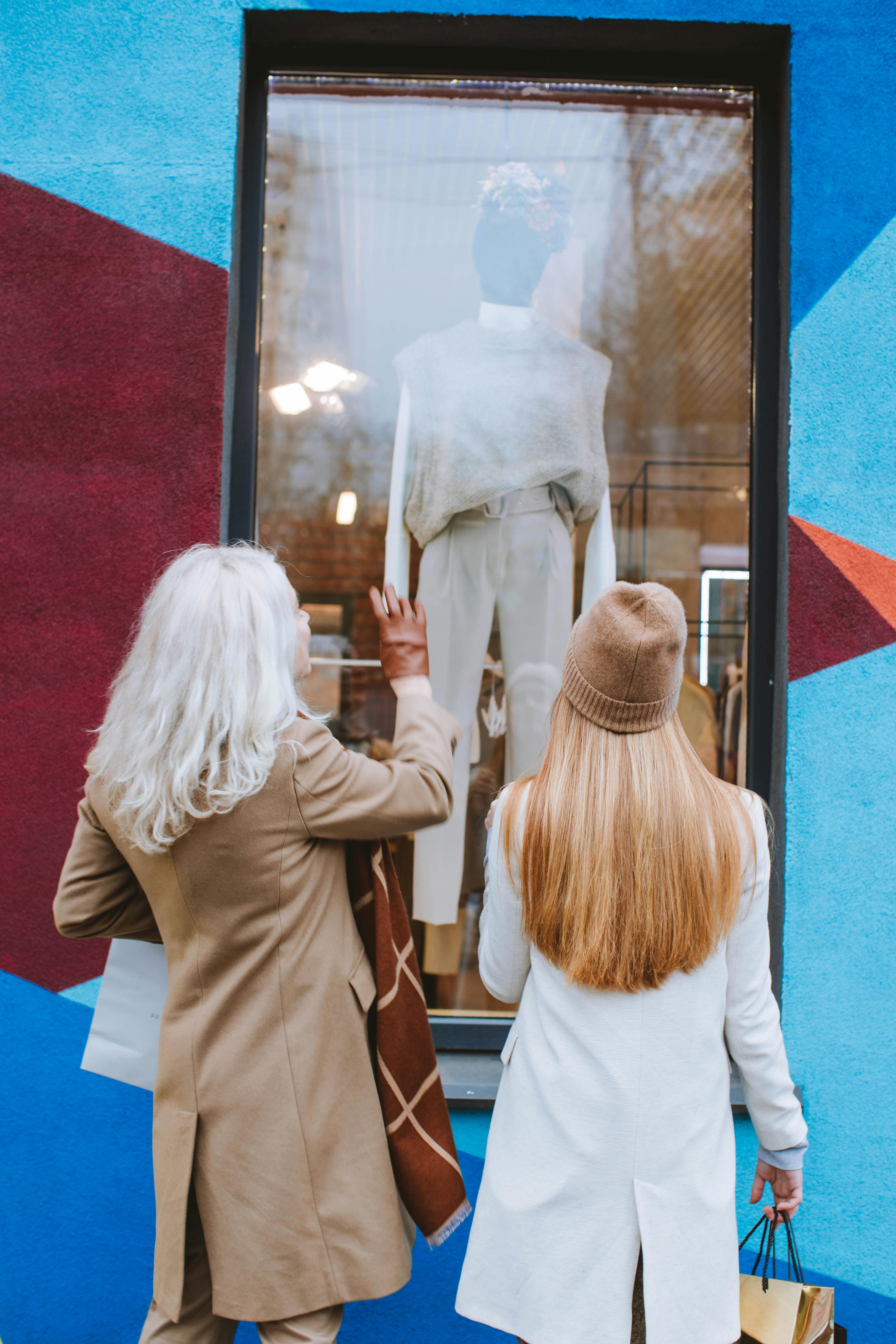 man and woman standing beside glass window