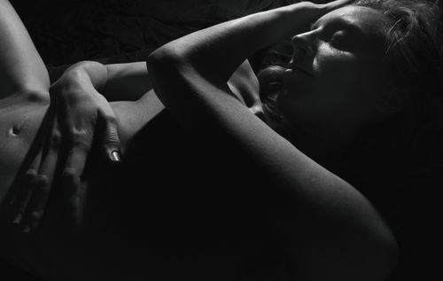 Free Black and white artistic portrait of a woman lying with eyes closed, creating a serene and moody atmosphere. Stock Photo