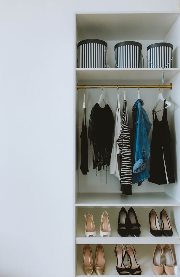 Organized small closet with hanging clothes and storage boxes