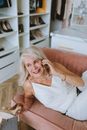 Woman in White Sleeveless Dress Sitting on Couch