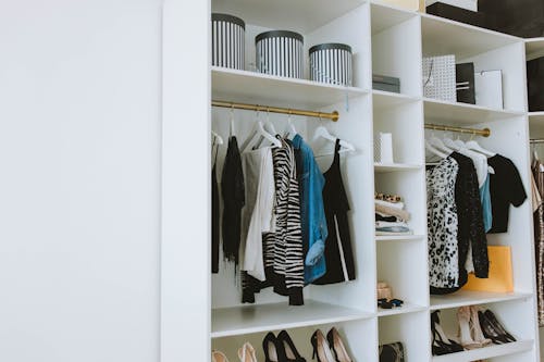 Clothes Hanged on White Wooden Cabinet