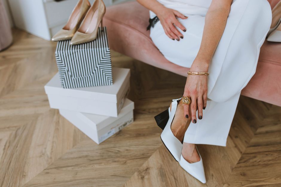 Chic woman trying on shoes in a stylish home setting, emphasizing modern fashion and luxurious lifestyle.