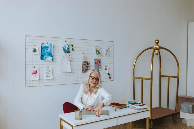deep green accent wall behind a small white desk