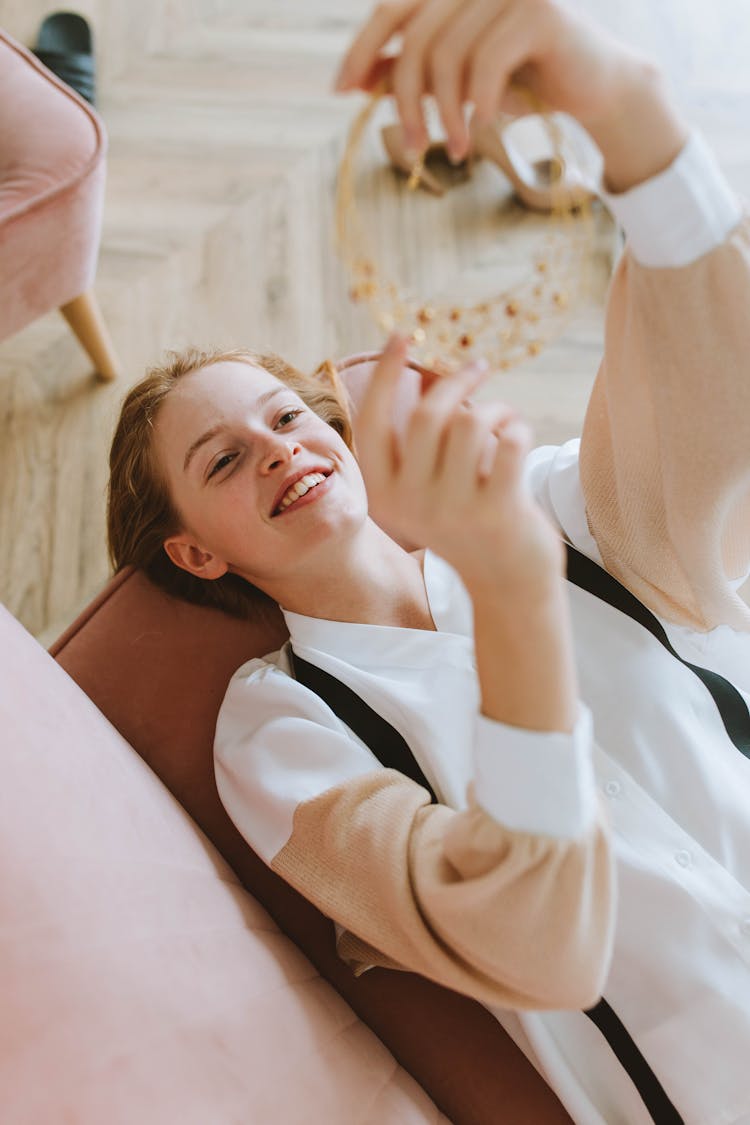 Happy Young Woman Lying On A Sofa 