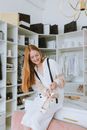 在一家现代精品店里，一位年轻女子快乐地拿着鞋子，氛围别致时尚