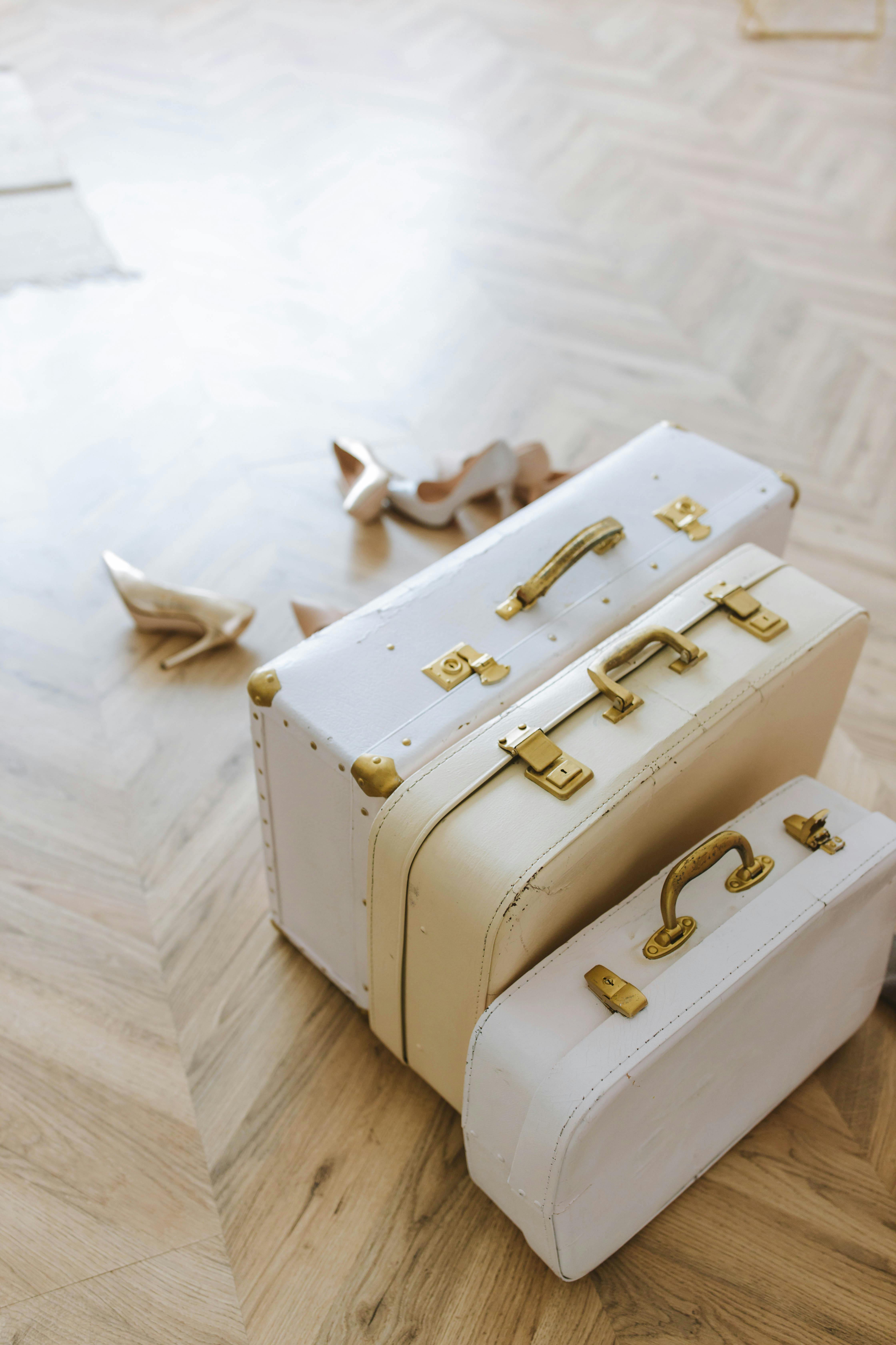 a suitcases with gold handles on a wooden floor