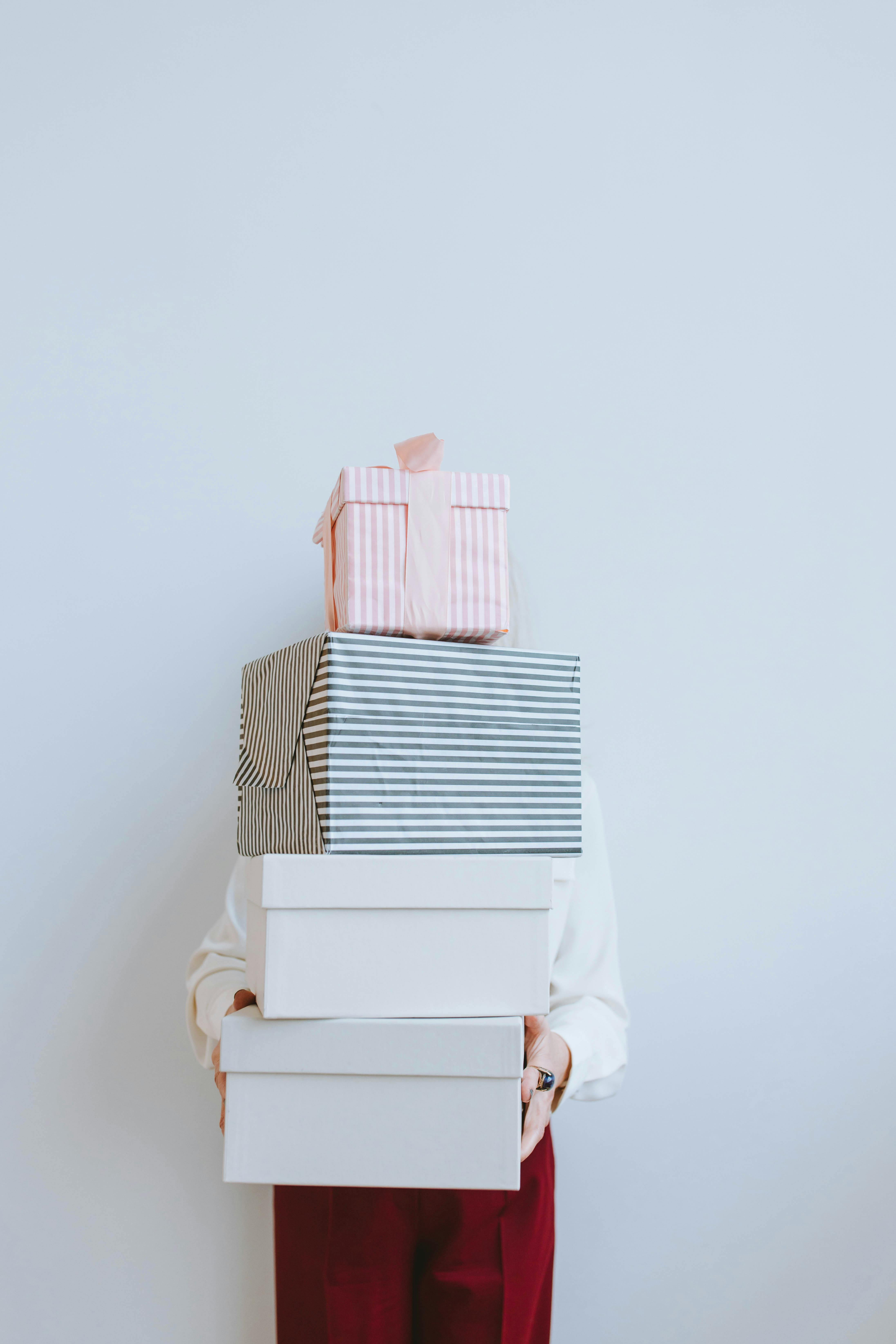 Person holding a pile of gift boxes