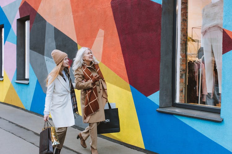 Mother And Daughter Carrying Shopping Bags