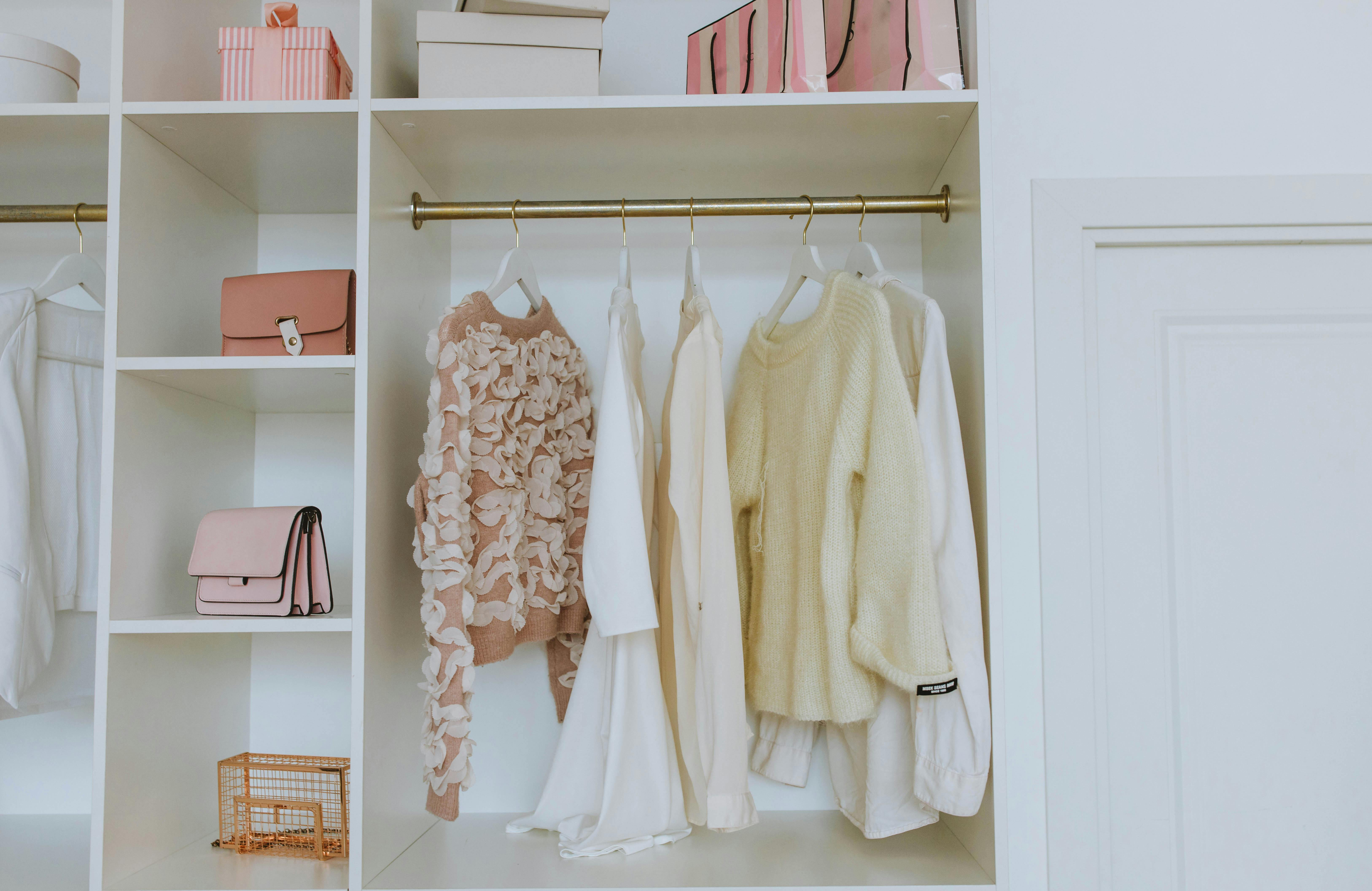 A closet with clothes and purses