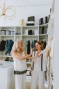 两名妇女在一个别致的衣柜设置中，享受着配有豪华货架的时尚造型