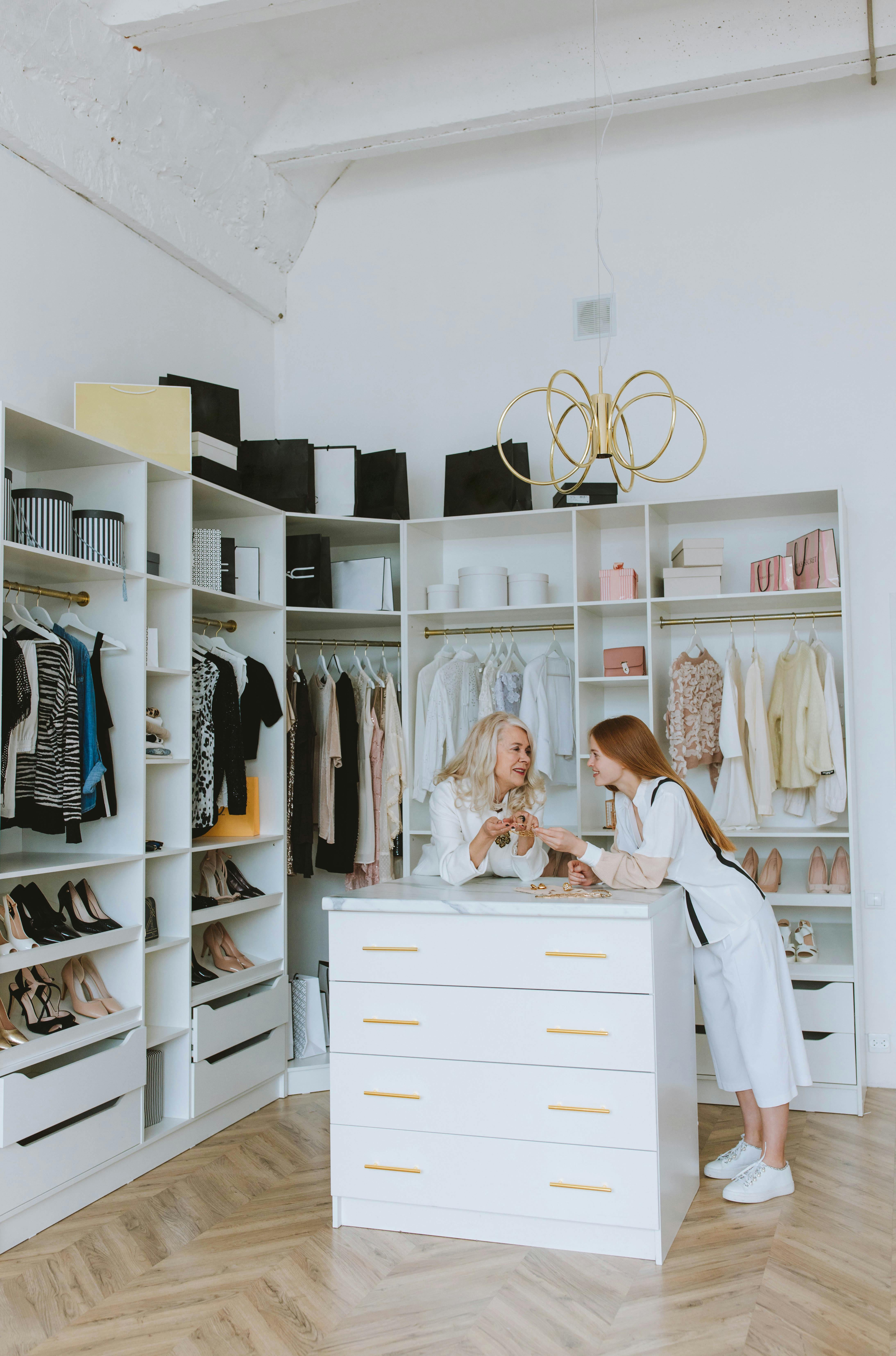 woman and girl standing beside cabinet in wardrobe