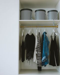 Organized wardrobe with trendy clothes, hangers, and storage boxes.