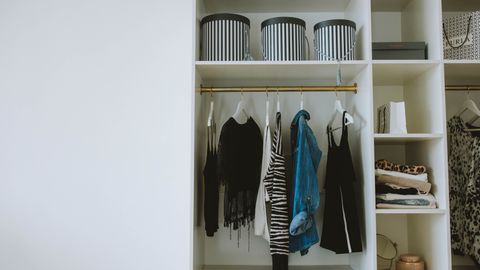Organized wardrobe with trendy clothes, hangers, and storage boxes.