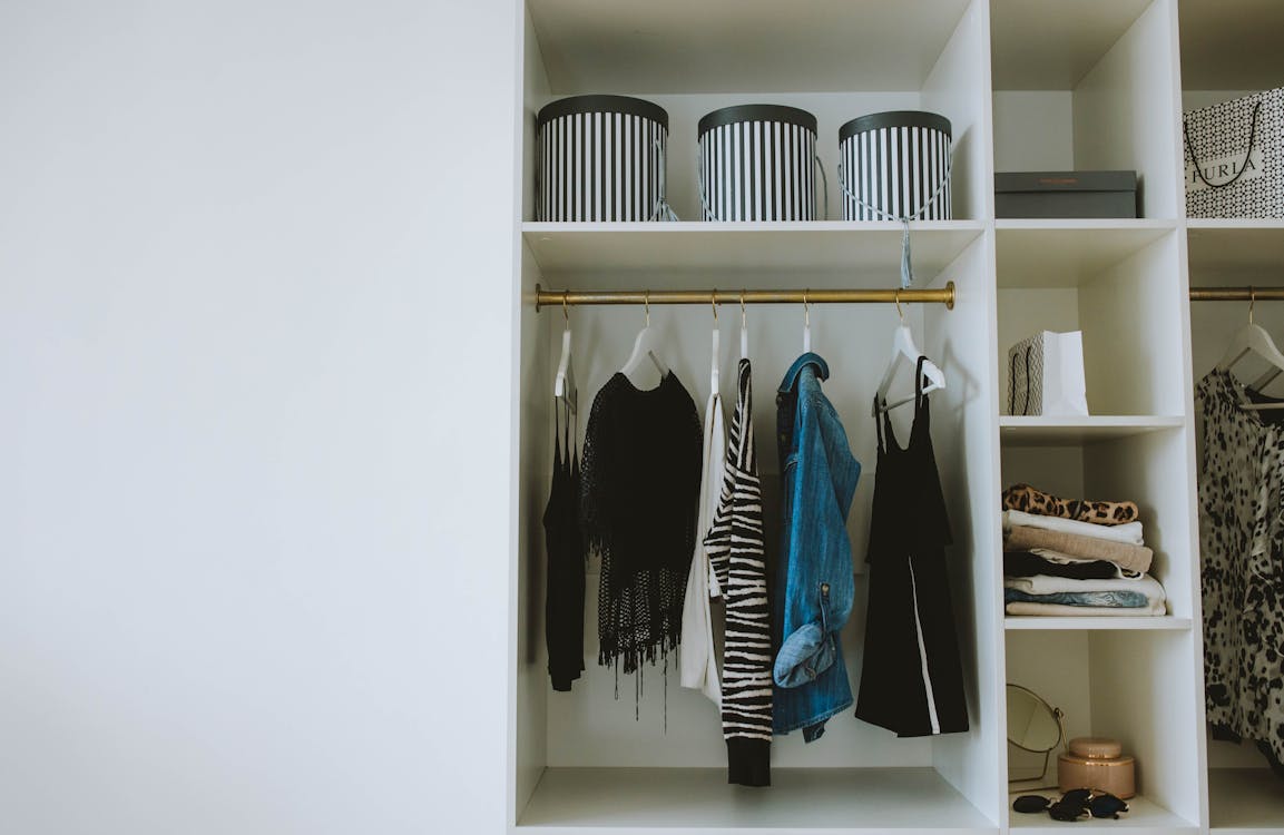 Blue and Black Jackets Hanged on White Wooden Cabinet