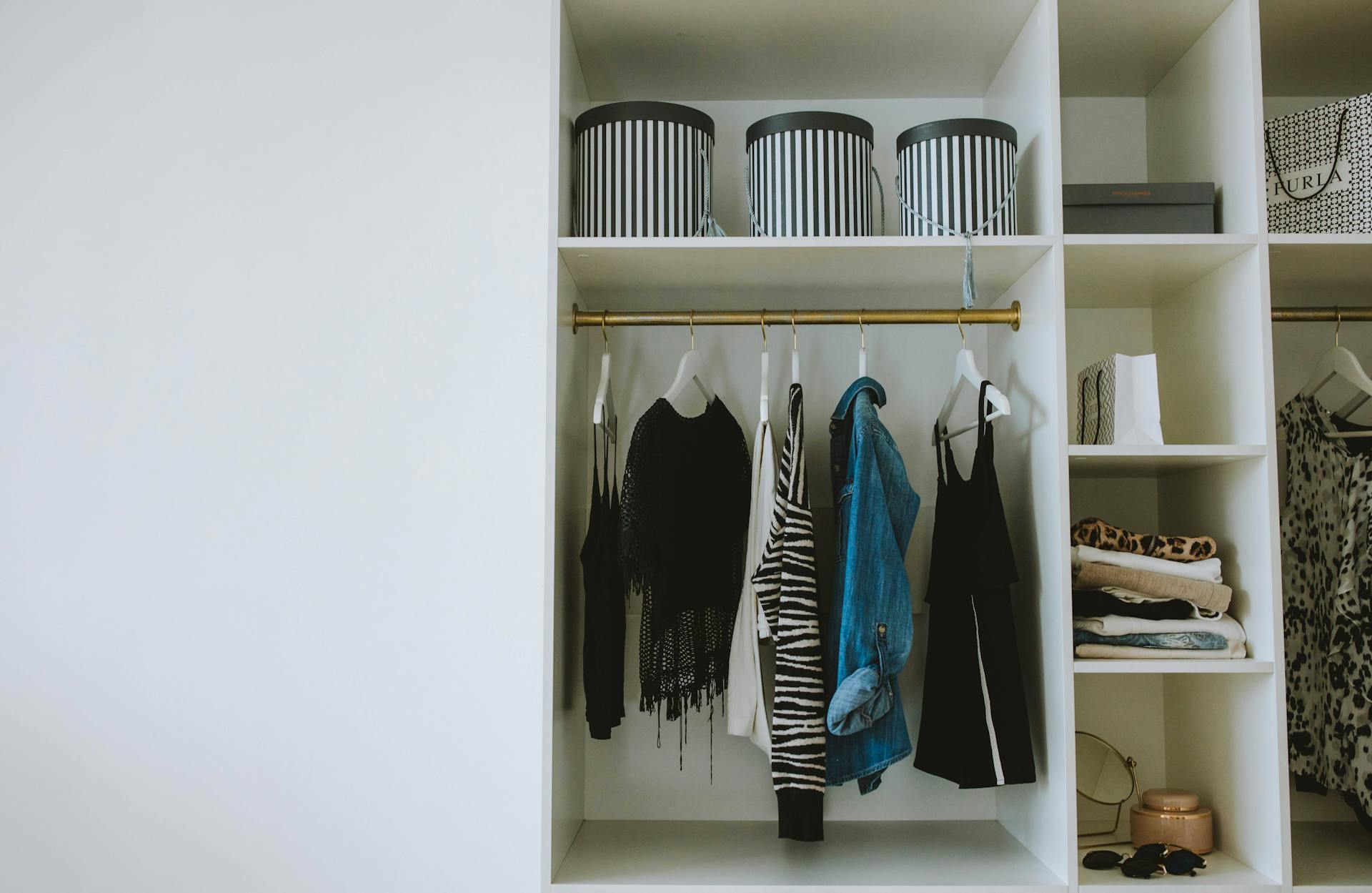 Organized wardrobe with trendy clothes, hangers, and storage boxes.