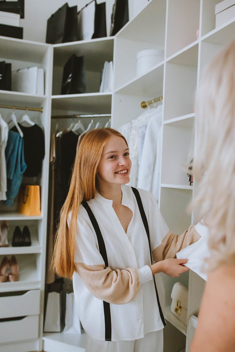 Woman In Long Sleeve Shirt Smiling Inside A Walk-in Closet