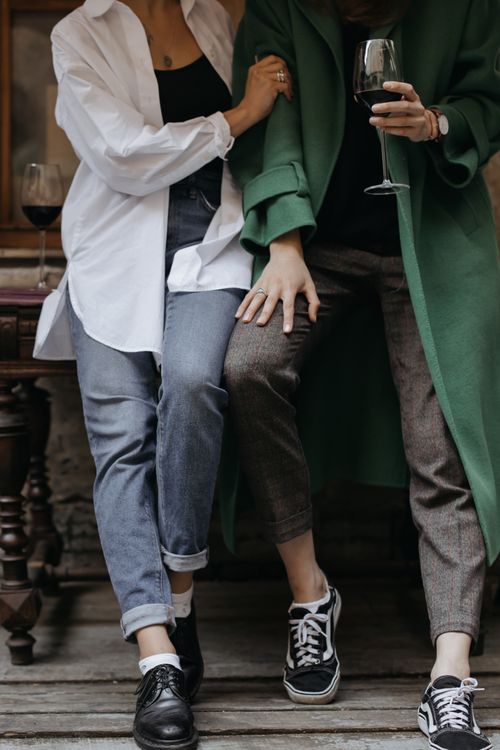 Free Two stylish young women sharing a bonding moment over wine in a cozy indoor café setting. Stock Photo