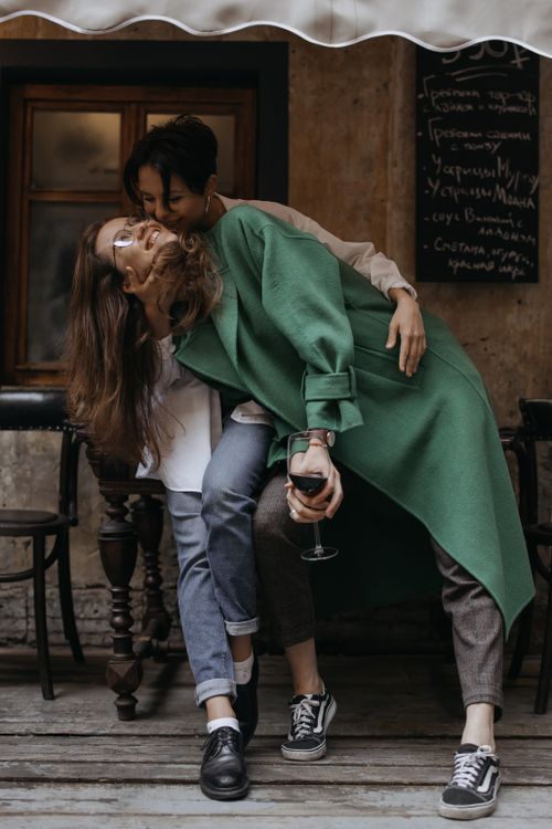 Free A joyful couple shares a moment, embracing outside with a wine glass in hand. Stock Photo
