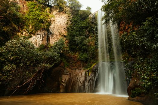 Beautiful waterfall surrounded by lush greenery in Cerveteri, Lazio, Italy.