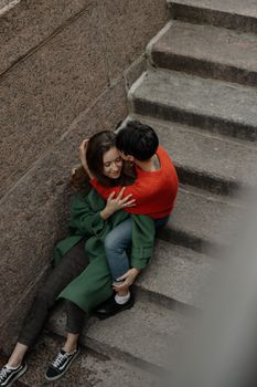 一对夫妇在石楼梯上深情拥抱，展现了爱与团结