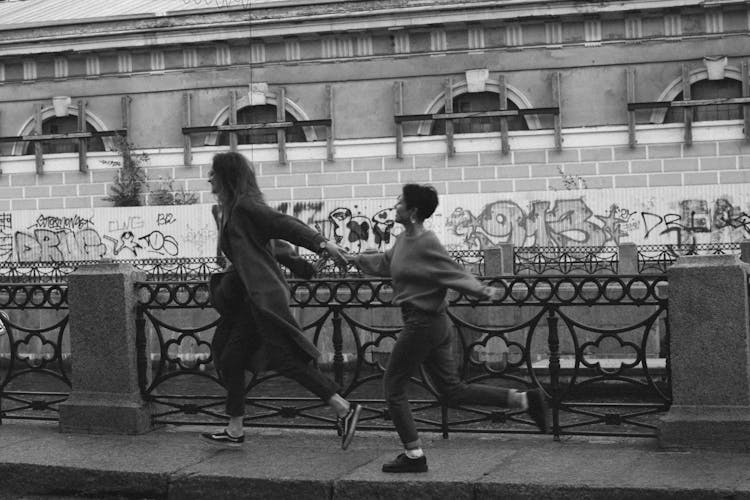 Two Women Running On The Sidewalk