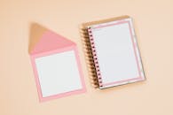 以桃子为背景的粉红色笔记本和信封扁平布局，提供了充足的版权空间