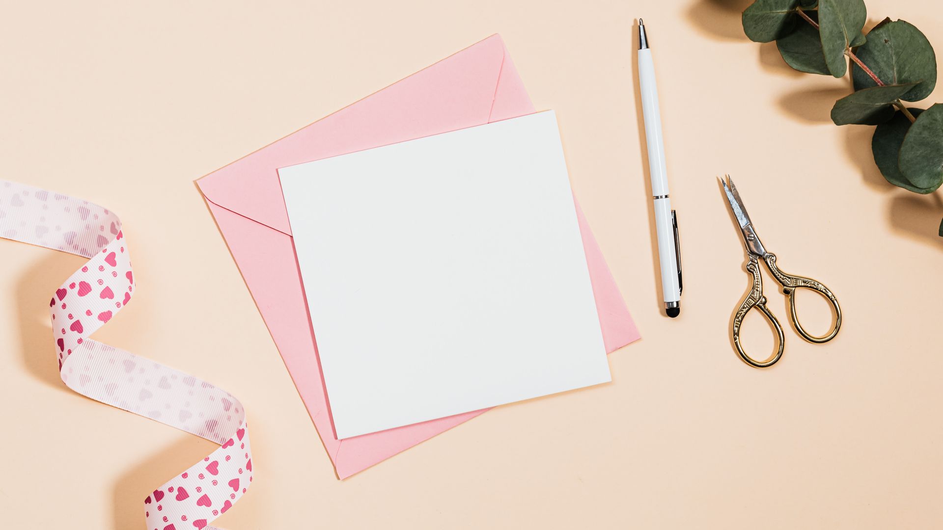 Wedding Cards: Your Guide to the Perfect Invitation 5 Flat lay of stationery including pink envelopes, scissors, and leaves on a pastel background — wedding cards