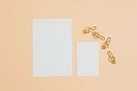 Photo of Gold Paper Clips Near Blank Cards