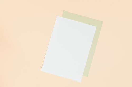 Blank Pieces of Paper Against Yellow Background