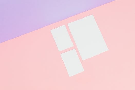 A pastel pink and purple background showcasing a minimalist mockup with white paper pieces for creative design.