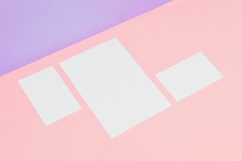 Free Photograph of Blank Pieces of Paper on a Pink Surface Stock Photo