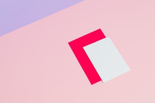 Photograph of a White on Top of a Bright Pink Paper 