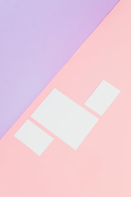 Photo of Blank Pieces of Paper on a Pink Surface