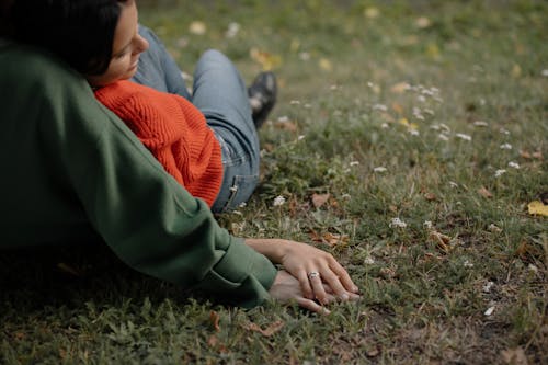 Boy in Red and Gray Jacket Lying on Green Grass Field
