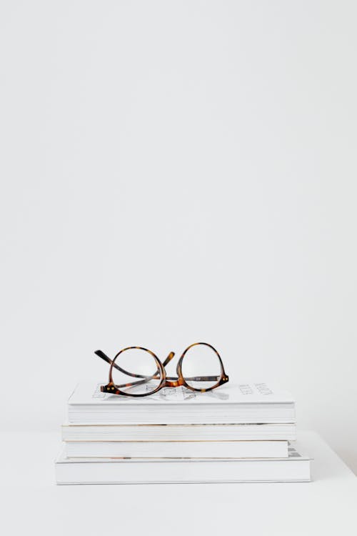 Brown Framed Eyeglasses On Books