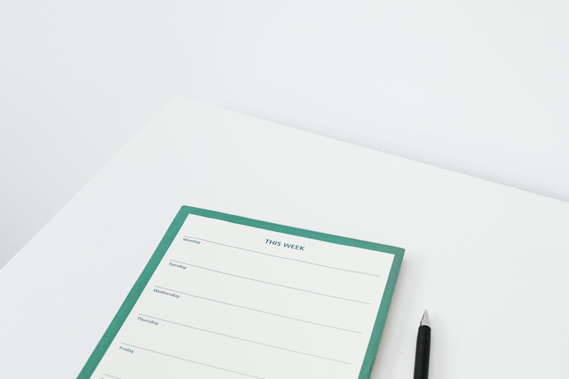 Free Weekly Planner Next to a  Black Pen Stock Photo
