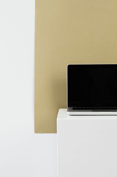 Minimalistic laptop on white podium, ideal for tech displays and presentations.