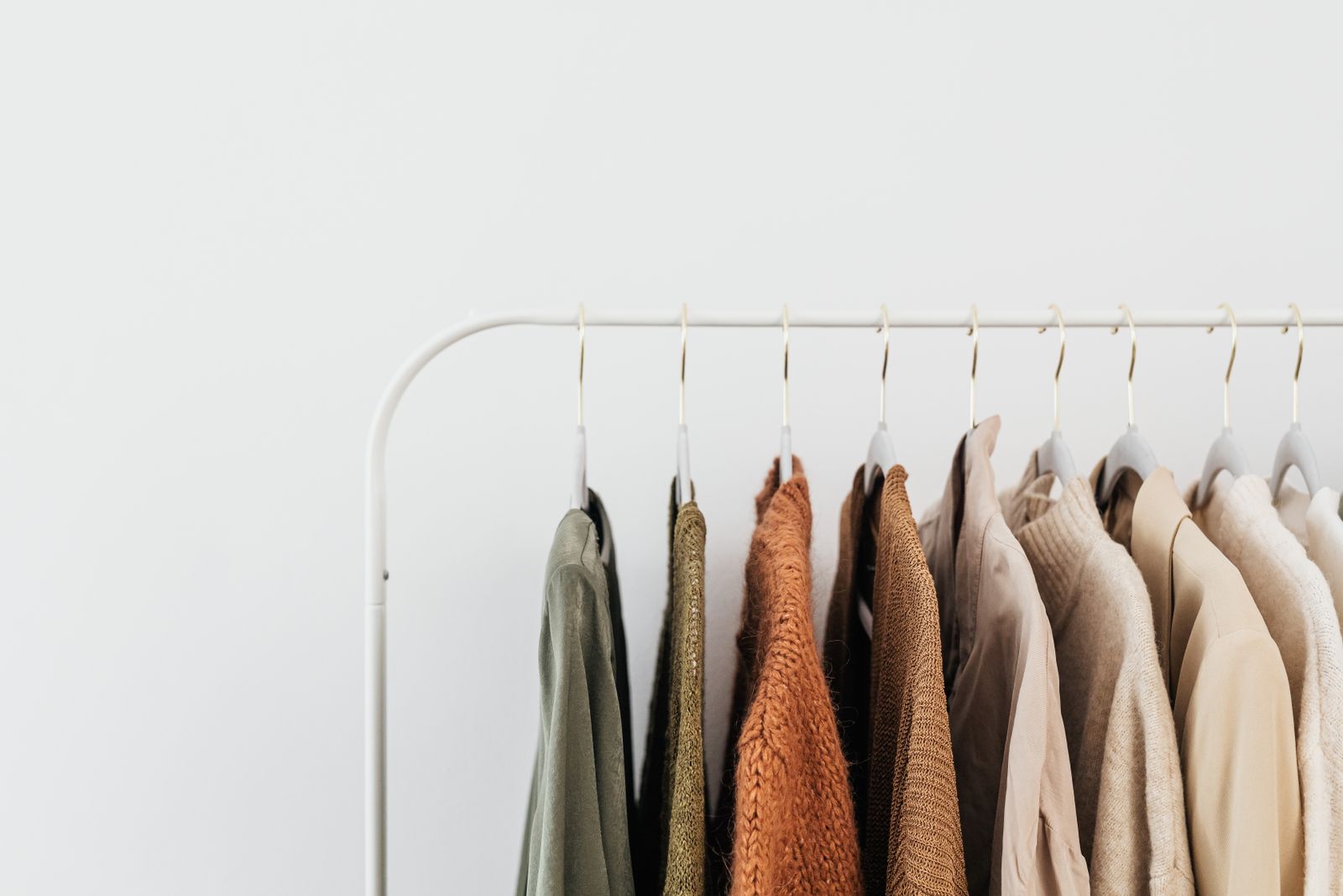 Minimalist clothing rack with neutral toned outfits