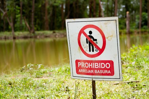 Close Up Photo of Red and White Signage on Grass Field