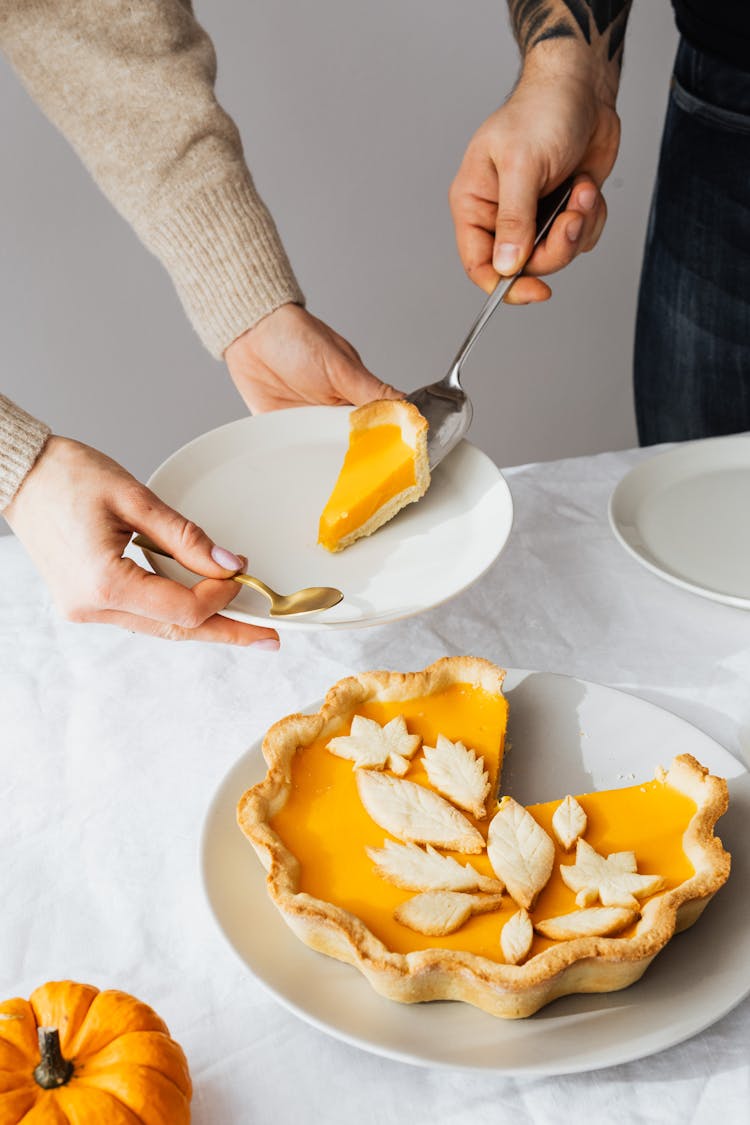 Woman And Man Putting Cake Slice On Plate