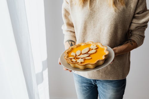 Free Person in Gray Sweater Carrying Pumpkin Pie  Stock Photo
