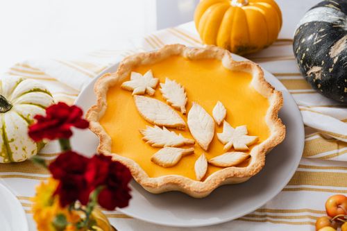 Free Close-up of a beautifully decorated pumpkin pie with autumn leaf cutouts, perfect for fall celebrations. Stock Photo