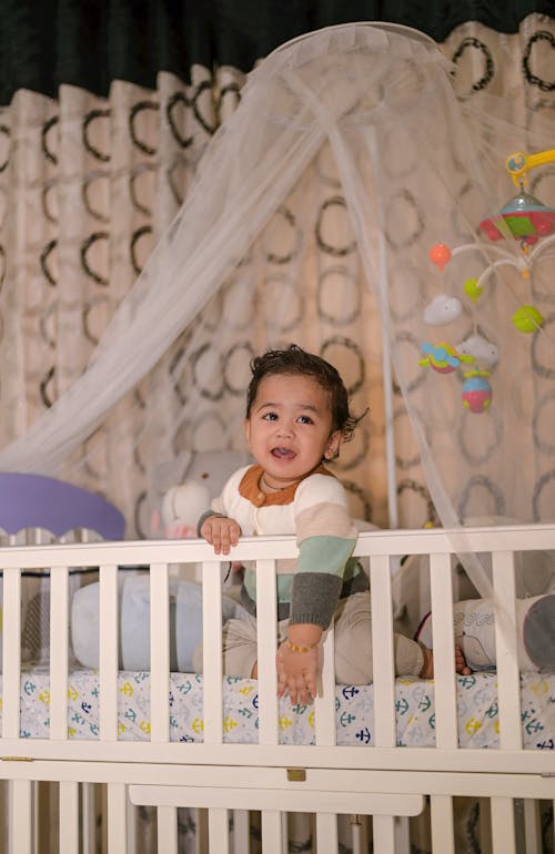 Free A Smiling Toddler on the White Crib Stock Photo