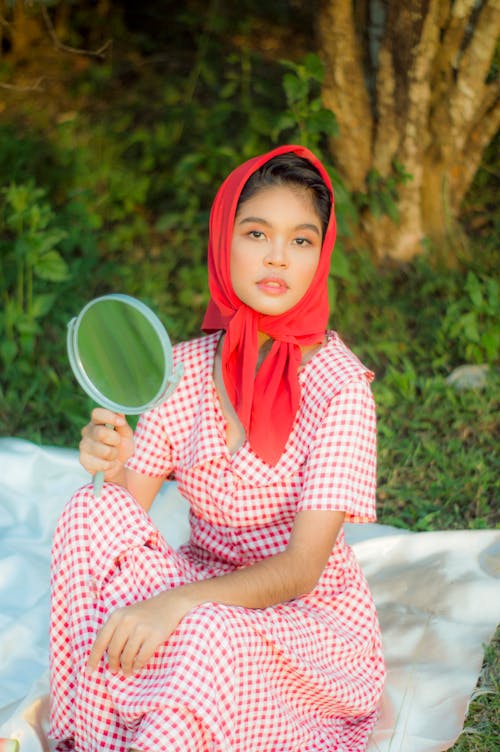 Woman in Red and White Checkered Dress Holding a Mirror