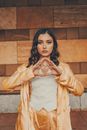 Emotionless model showing illuminati triangle gesture