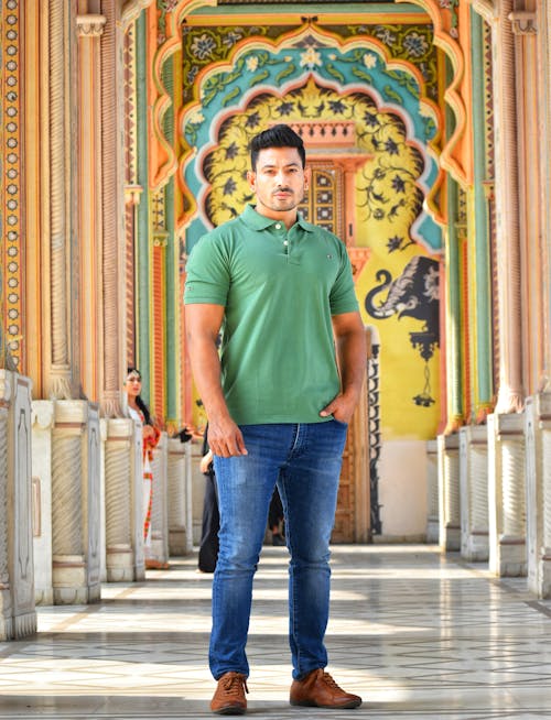 A Man in Green Polo Shirt and Denim Jeans Standing on the Hallway